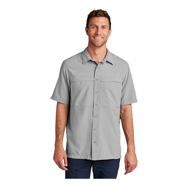 A man wearing a Port Authority short sleeved shirt in gusty gray with a UPF rating of 30.