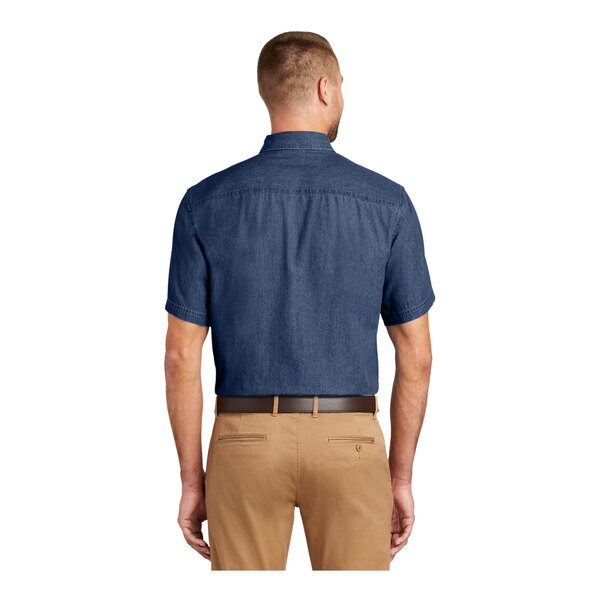 A man wearing an ink blue Port & Company long sleeve denim button-down shirt.