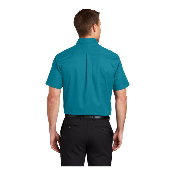 A man wearing a teal Port Authority dress shirt with short sleeves.