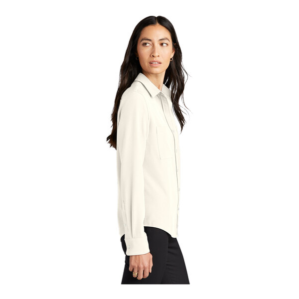 A woman wearing a Mercer+Mettle ivory chiffon long sleeve camp blouse.
