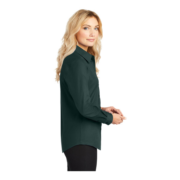 A woman wearing a Port Authority dark green long sleeve dress shirt.