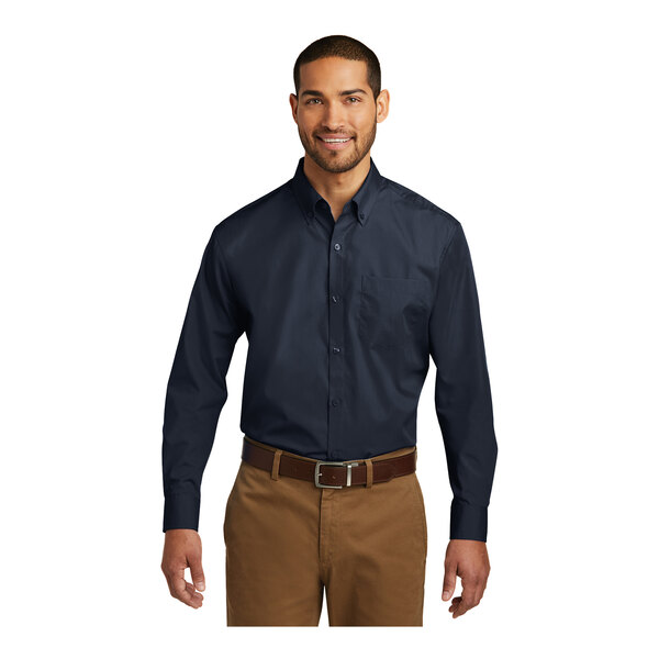 A man wearing a Port Authority river blue long sleeve poplin shirt.