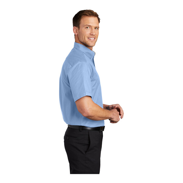 A man wearing a Port Authority light blue short sleeve dress shirt.
