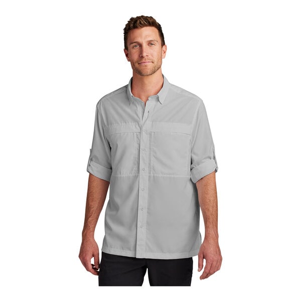 A man wearing a Port Authority long sleeve shirt in white.