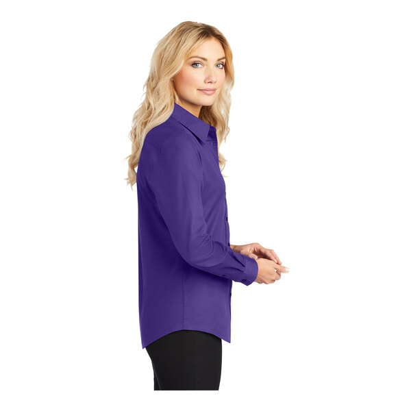 A woman wearing a purple and light stone Port Authority ladies long sleeve button down shirt.