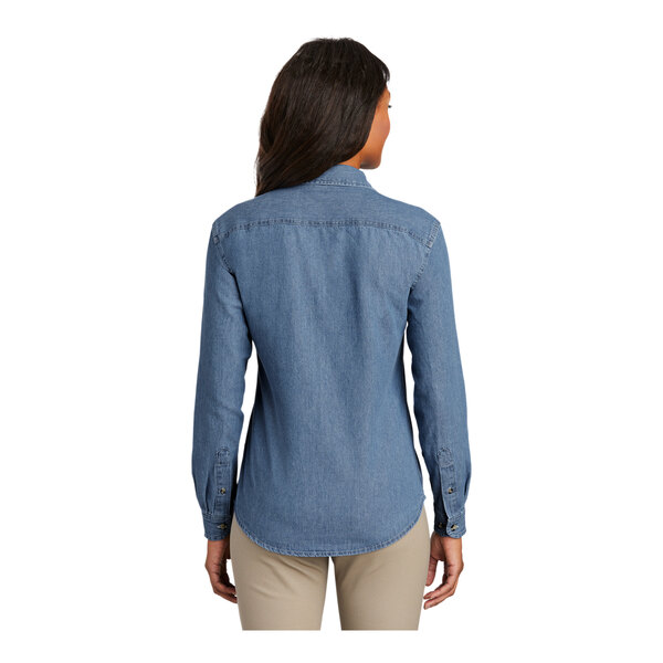 A woman wearing a Port & Company faded blue short sleeve denim button-down shirt.