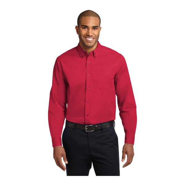 A man wearing a red Port Authority long sleeve dress shirt in a red and light stone colorblock pattern.