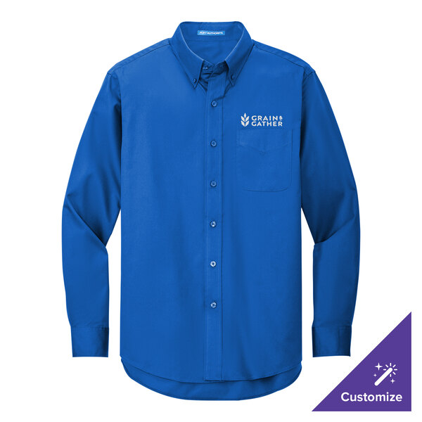 A Port Authority long sleeve blue dress shirt with a logo on the chest.