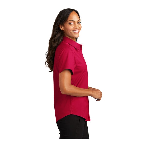 A woman wearing a red Port Authority short sleeve dress shirt.
