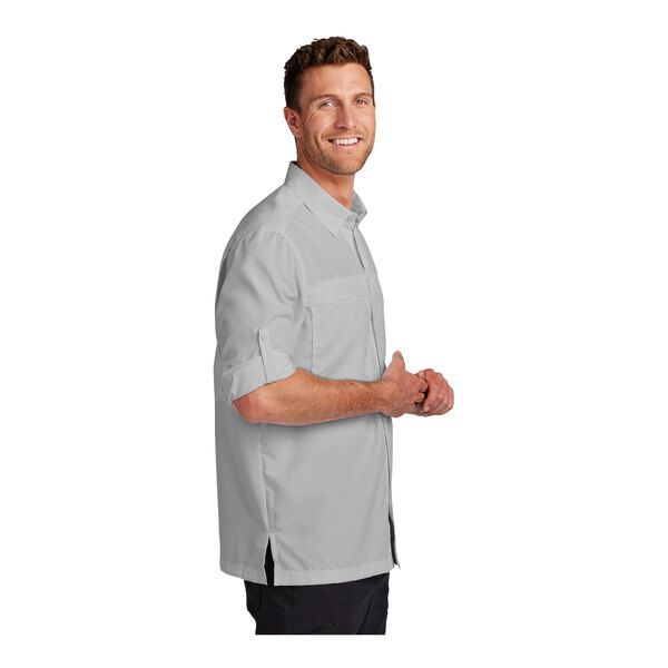 A man wearing a Port Authority long sleeve shirt in white.