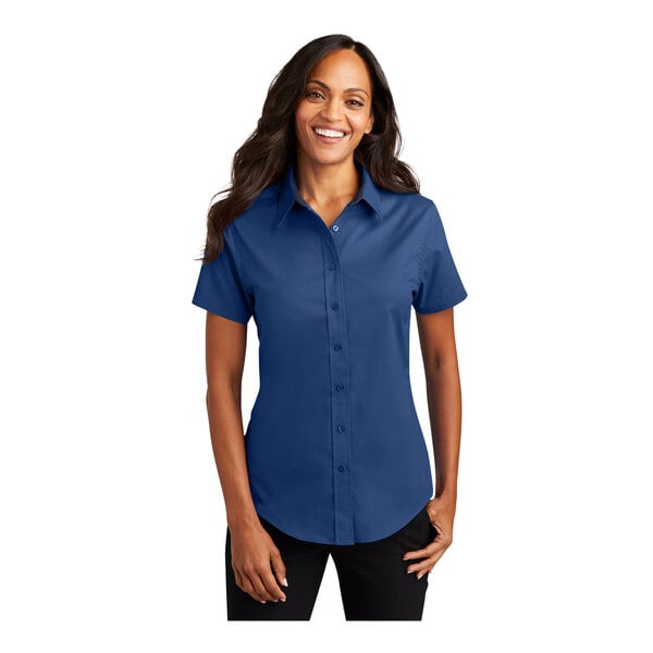 A woman wearing a royal blue Port Authority short sleeve dress shirt.