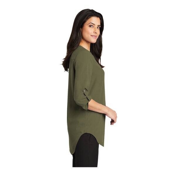A woman wearing a Port Authority deep olive short sleeve blouse.