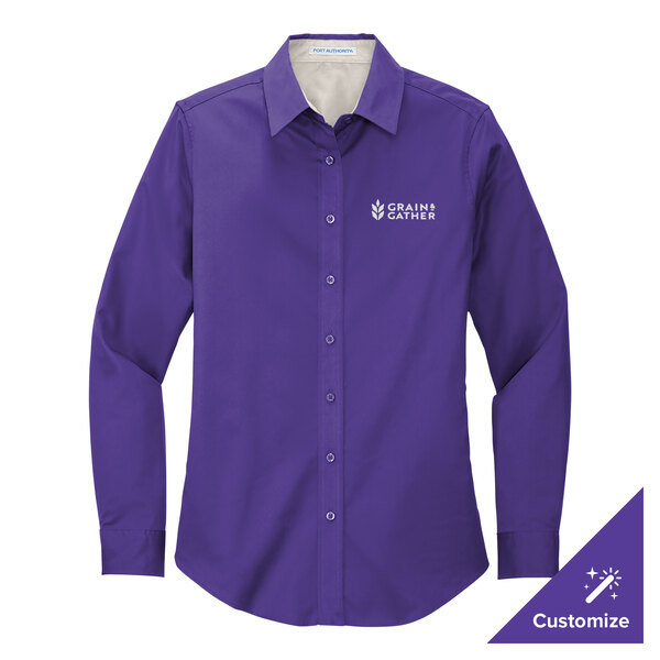 A Port Authority long sleeve purple dress shirt on a counter with the logo of the company.