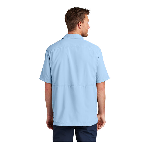 A man wearing a light blue Port Authority short sleeve shirt.