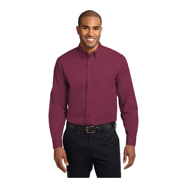 A man wearing a Port Authority long sleeve burgundy and light stone dress shirt.