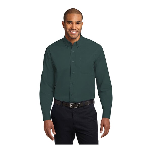 A man wearing a Port Authority long sleeve dark green dress shirt.