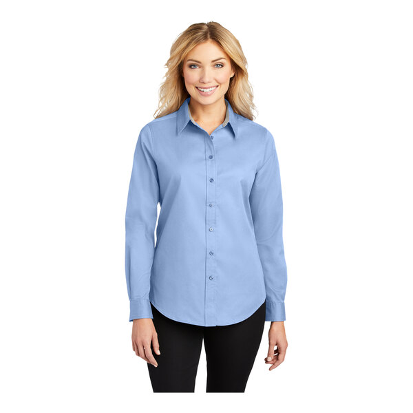 A woman wearing a light blue Port Authority long sleeve button up shirt.