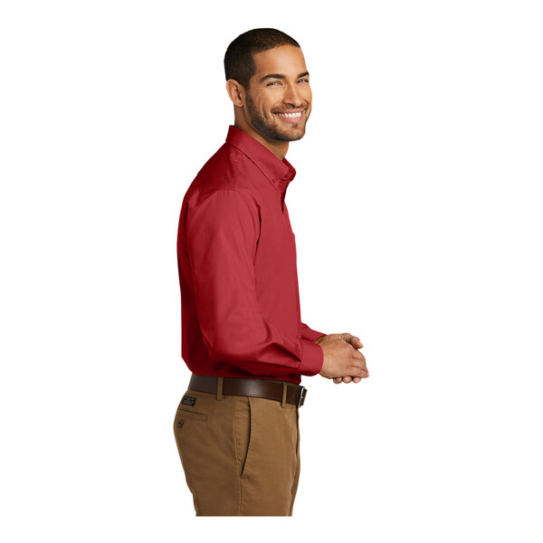 A man wearing a rich red Port Authority long sleeve poplin dress shirt.