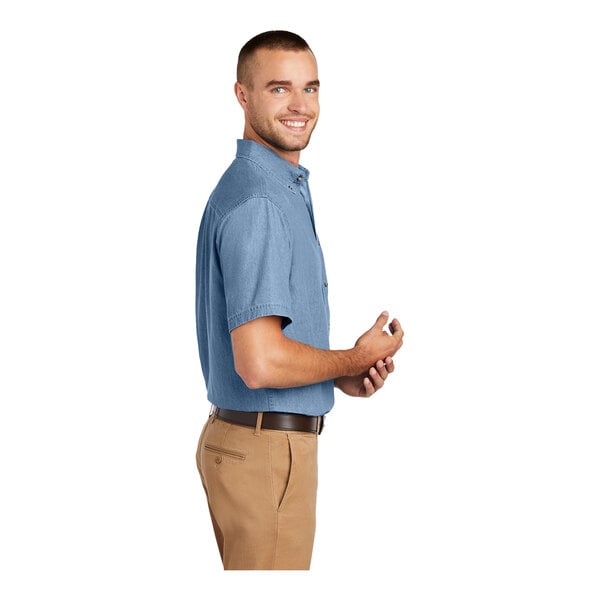A man wearing a faded blue Port & Company short sleeve denim button-down shirt.