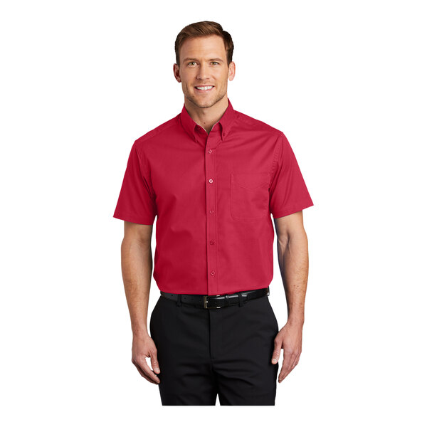 A man wearing a red Port Authority short sleeve dress shirt in red and light stone.