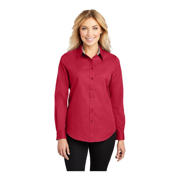 A woman wearing a red Port Authority long sleeve dress shirt.