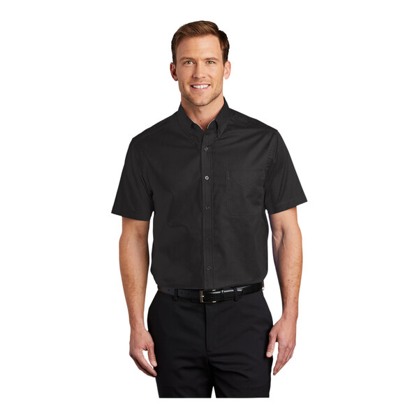 A man wearing a black and light stone Port Authority short sleeve dress shirt.
