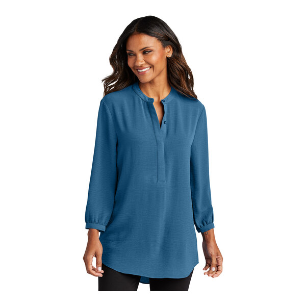 A woman wearing a blue Port Authority short sleeve blouse.
