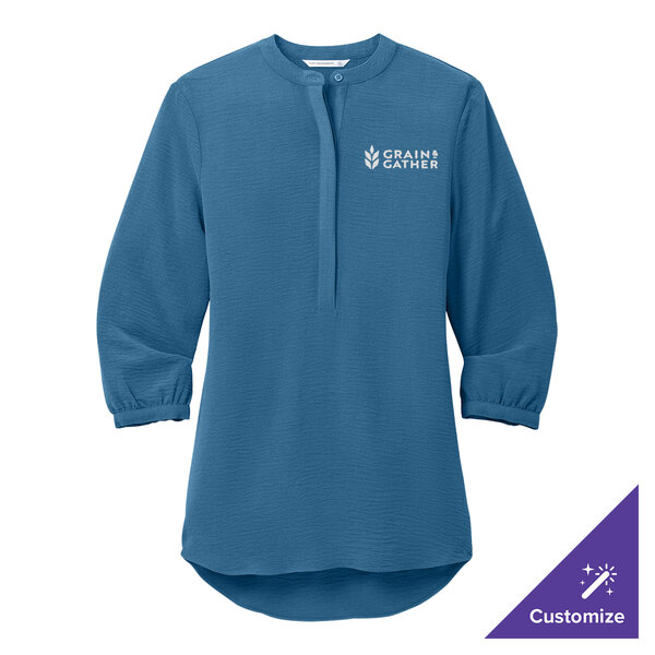 A Port Authority Aegean blue textured crepe tunic blouse with a logo on the front.