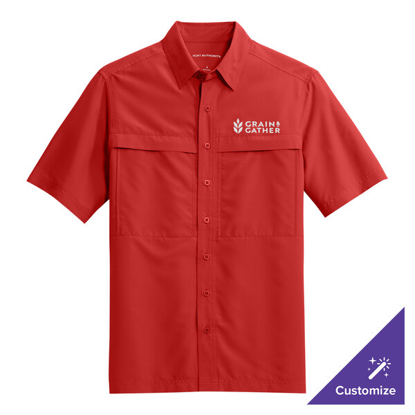 A Port Authority rich red short sleeve shirt with a logo on the chest.