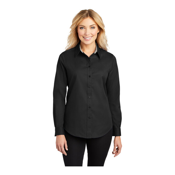 A woman wearing a black and light stone Port Authority ladies' long sleeve dress shirt.