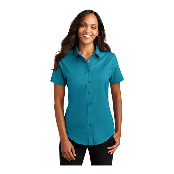 A woman wearing a teal green Port Authority short sleeve button down dress shirt.