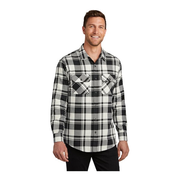 A man wearing a Port Authority black and white plaid flannel shirt.