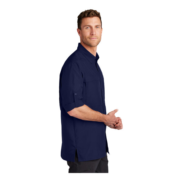 A man wearing a Port Authority blue stretch poplin shirt.