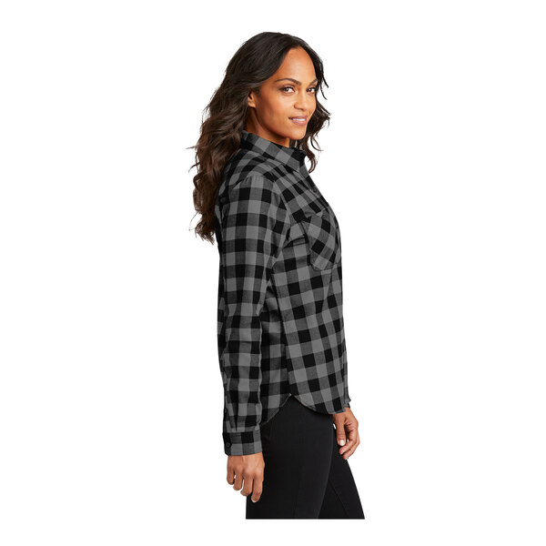 A woman wearing a gray, black, and white buffalo check flannel shirt.