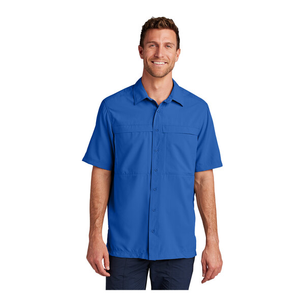 A man wearing a Port Authority blue short sleeve shirt.