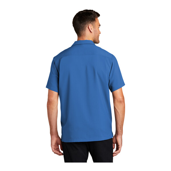 A man wearing a blue Port Authority staff shirt with short sleeves.