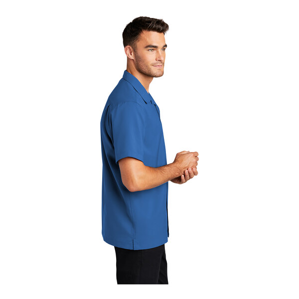 A man wearing a Port Authority short sleeve blue performance staff shirt.