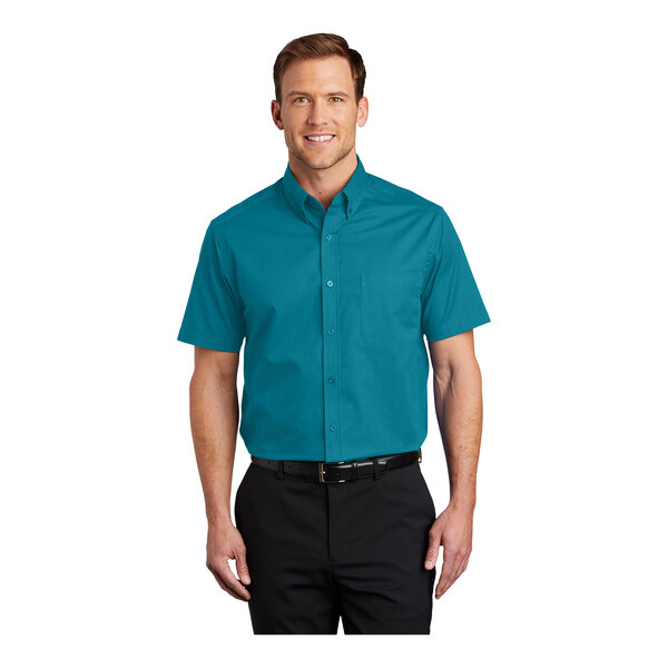 A man wearing a Port Authority teal green short sleeve dress shirt.