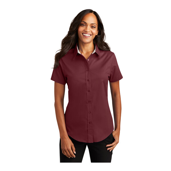 A woman wearing a Port Authority burgundy and light stone short sleeve button down dress shirt.