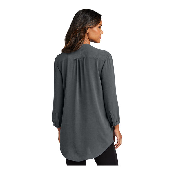 A woman wearing a graphite Port Authority short sleeve blouse.