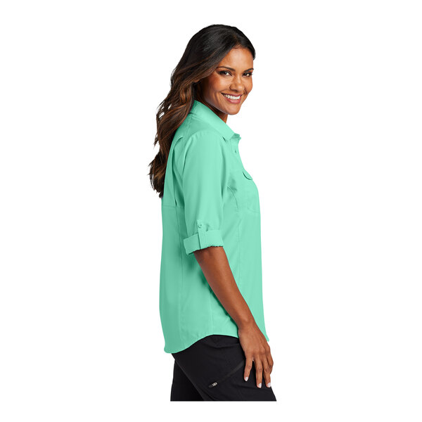 A woman wearing a bright seafoam short sleeve shirt.