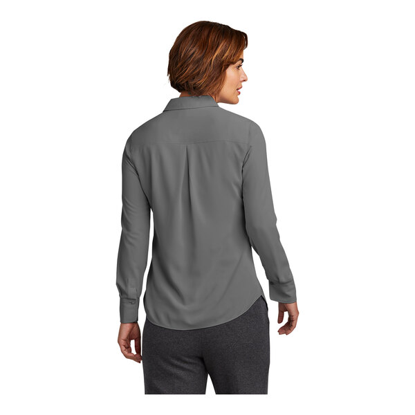 A woman wearing a shadow gray Brooks Brothers long sleeve shirt.