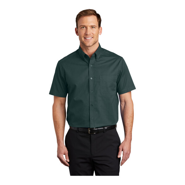 A man wearing a dark green Port Authority dress shirt with short sleeves.