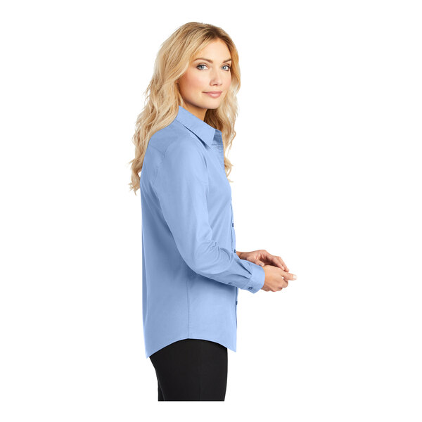 A woman wearing a light blue Port Authority long sleeve dress shirt.