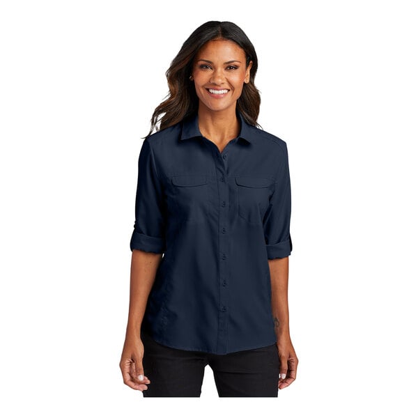 A woman wearing a Port Authority blue short sleeve shirt.