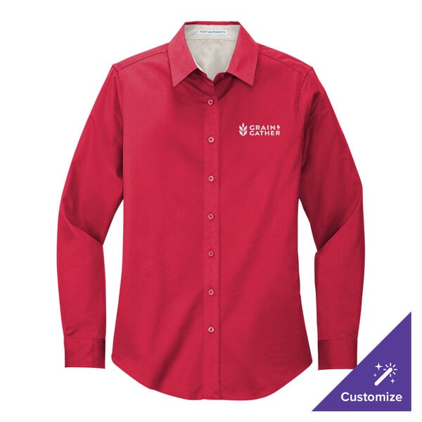 A red Port Authority long sleeve dress shirt on a counter with the logo of the company.