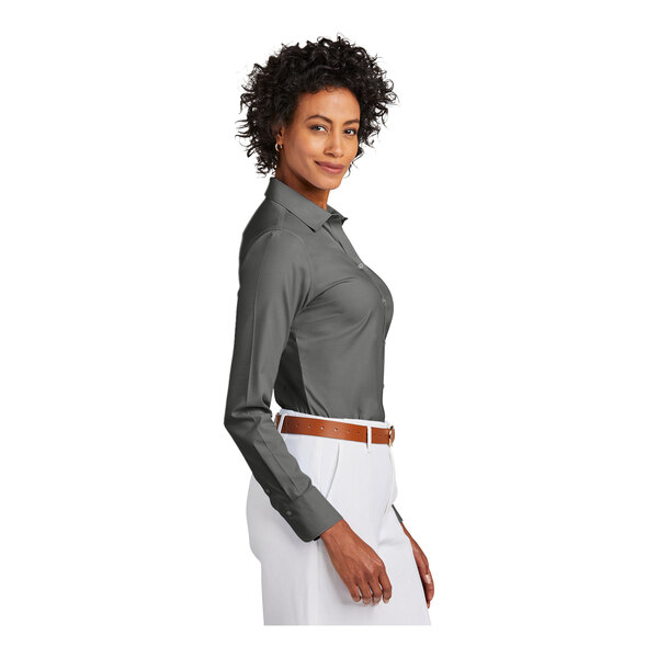 A woman wearing a medium black Brooks Brothers long sleeve dress shirt.