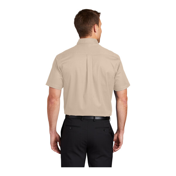 A man wearing a stone Port Authority short sleeve dress shirt.