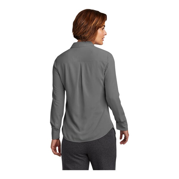 A woman wearing a shadow gray Brooks Brothers long sleeve shirt.