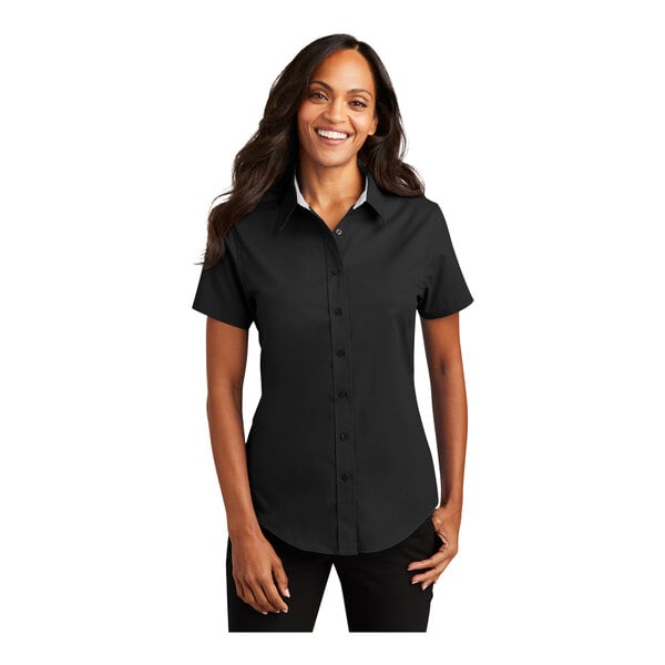 A woman wearing a Port Authority black and light stone short sleeve shirt.